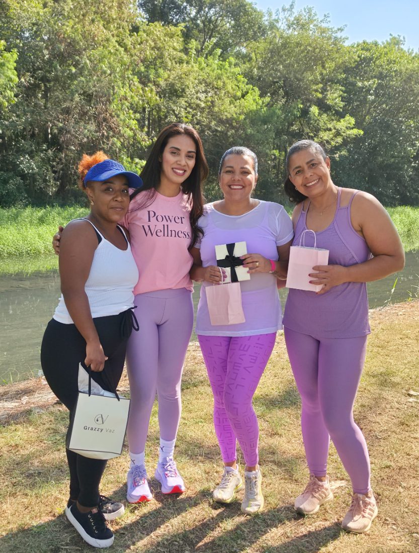 Grazzy Vaz com participantes segurando os brindes do encontro à beira do lago