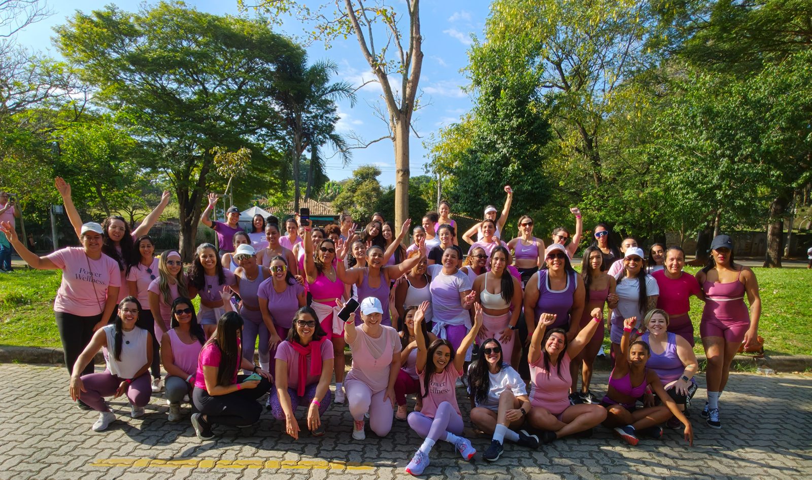 Grande grupo de mulheres reunidas e comemorando no 1º encontro Power Wellness, no Parque Ecológico da Pampulha