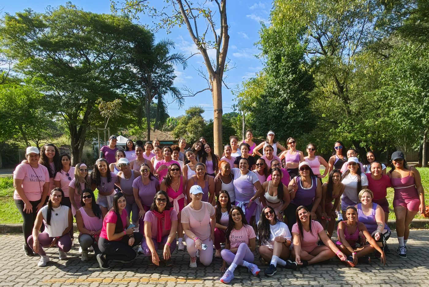 Foto coletiva das participantes do encontro Power Wellness em meio à natureza do parque