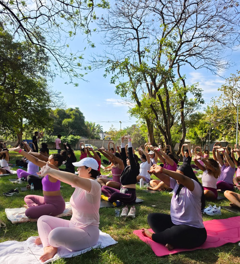 Mulheres em prática de yoga com os braços alongados sobre os tapetes no parque